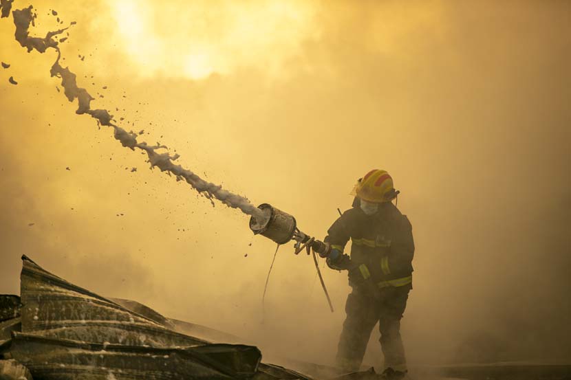 A fireman battles a blaze at a trash dump in Xiangyang, Hubei province, Nov. 11, 2020. People Visual