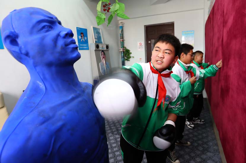 A boy works through his emotions by punching a dummy at a primary school counseling center in Huaibei, Anhui province, Nov. 15, 2020. People Visual