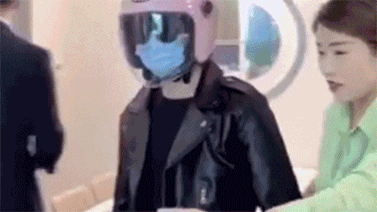 A GIF shows a man wearing a helmet at a real estate agency to avoid identification by facial-recognition cameras. From Weibo