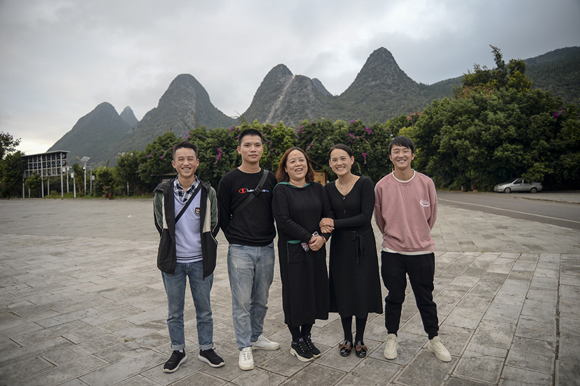 Huang Defeng (second from left), Wang Zhengzhi (center), and Li Xinmei (second from right) pose for a photo in Xingyi, Guizhou province, Oct. 27, 2020. Stephen Che/Guyu