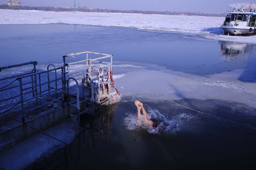 A winter swimmer leaps into the Songhua River in Harbin, Nov. 28, 2020. Wu Huiyuan/Sixth Tone