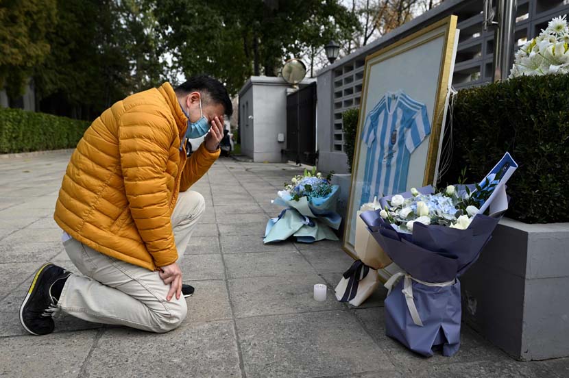 A fan pays his respects to the late Argentinian football legend Diego Maradona at the Embassy of Argentina in Beijing, Nov. 26, 2020. Wang Zhao/People Visual