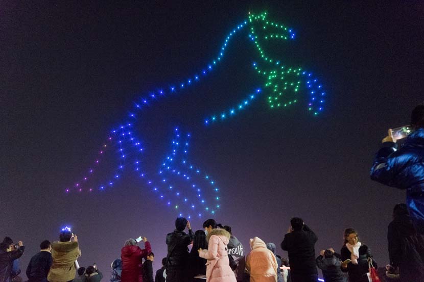 Onlookers take photos during a drone light show in Zhumadian, Henan province, Nov. 27, 2020. People Visual