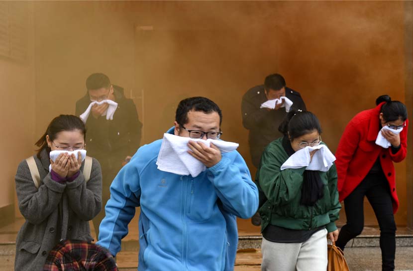 People evacuate from a building during a fire drill in Jinhua, Zhejiang province, Nov. 27, 2020. People Visual