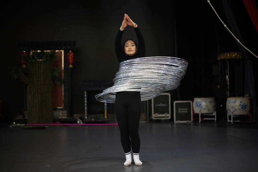 An acrobat practices hula hooping at an acrobatics school in Anqing, Anhui province, Dec. 9, 2020. People Visual