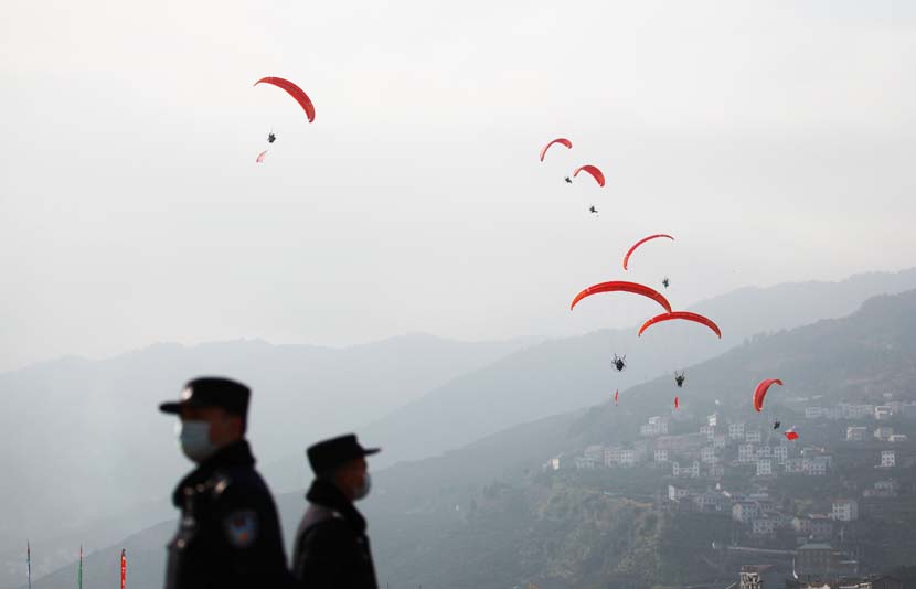 Police officers stand guard during a paragliding show in Yichang, Hubei province, Dec. 12, 2020. People Visual