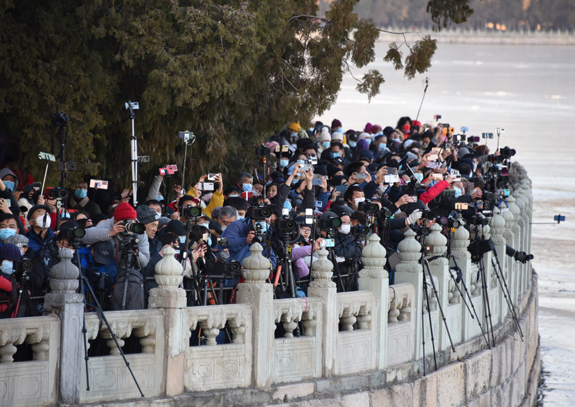 Visitors strain to take photos of Seventeen-Arch Bridge in the Summer Palace, Beijing, Dec. 20, 2020. People Visual