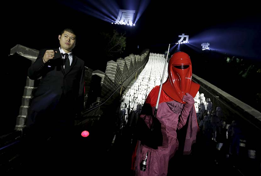 A person dressed as a “Star Wars” character poses for a photo in front of 500 replica Stormtroopers set up at the Great Wall for an event promoting the release of “Star Wars: The Force Awakens” in Beijing, Oct. 20, 2015. Li Jiangsong/People Visual
