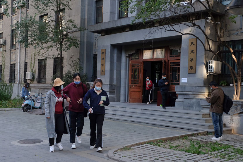 Students walk past the astronomy department building at Beijing Normal University, Oct. 13, 2020. Ye Ruolin/Sixth Tone