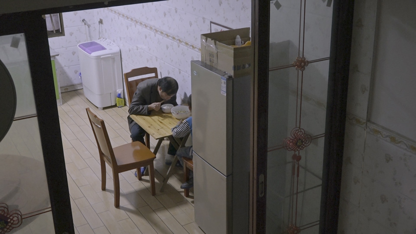 2020 年 9 月，龙代兵和他的小儿子在重庆农村的家里吃晚饭。龙放弃了在上海的工作，以便照顾家人。 六声刘敬文