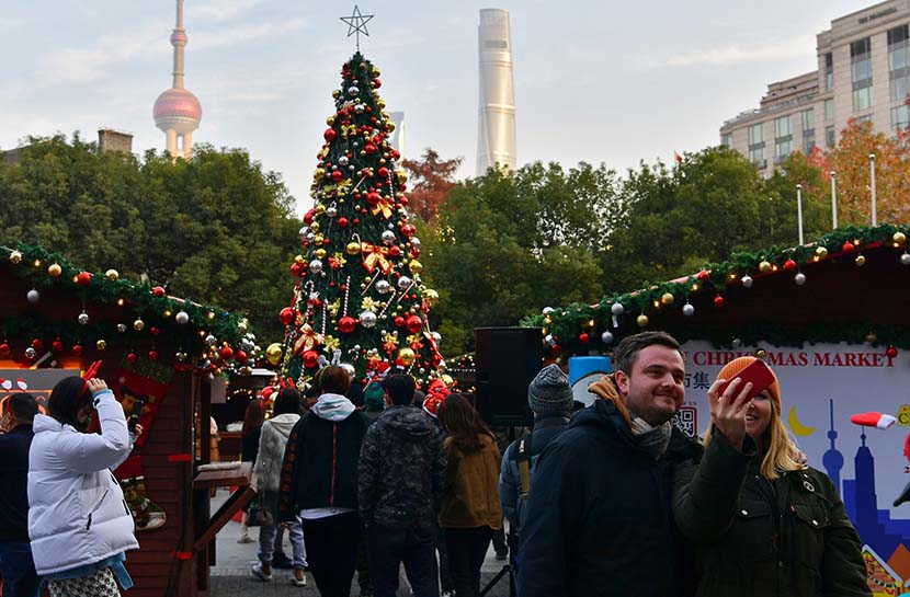 A couple takes a selfie at a Christmas market in Shanghai, Dec. 24, 2020. IC