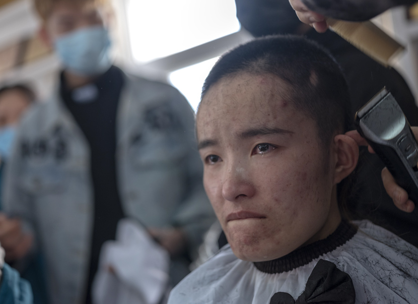 A nurse gets her hair shaved before being dispatched to the front lines of the coronavirus epidemic in Wuhan for medical support, in Sanmenxia, Henan province, Feb. 15, 2020. Du Jie via Xinhua