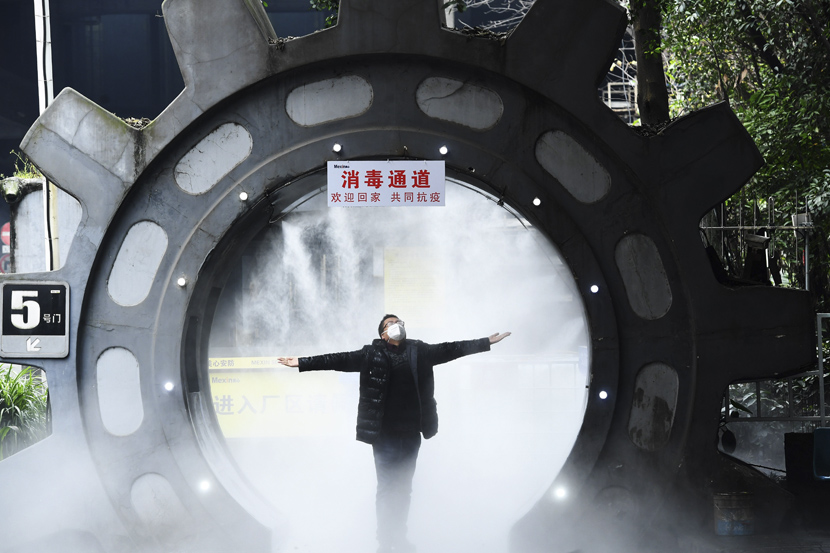 A staff member gets disinfected at the entrance of his company in Chongqing, Feb. 10, 2020. Chen Chao/CNS/People Visual