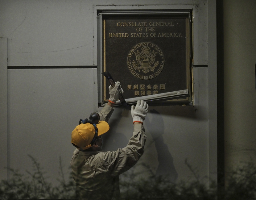 A worker dismantles a sign at the U.S. Consulate in Chengdu, Sichuan province, July 26, 2020. People Visual