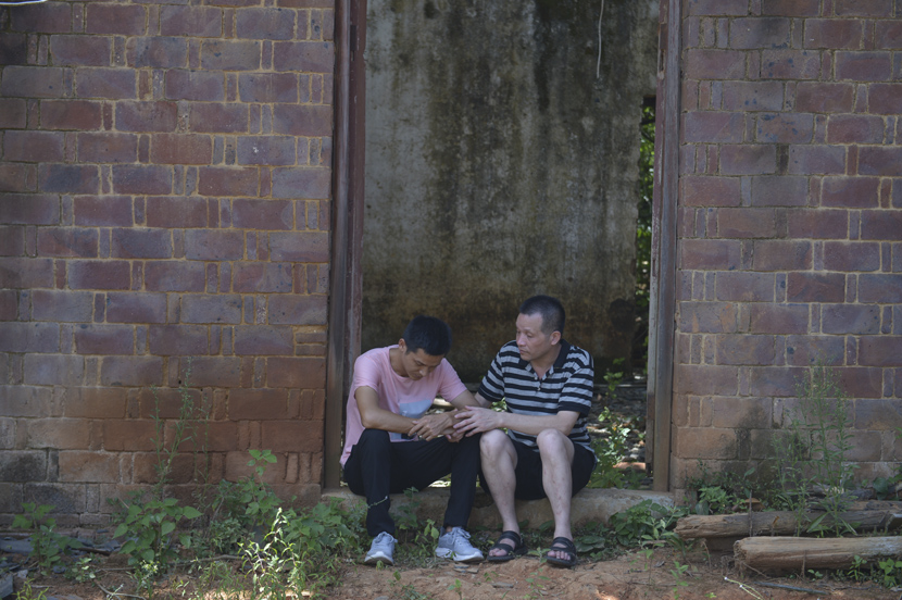 Zhang Yuhuan, who was wrongfully imprisoned for the longest period in China’s history, talks to his elder son at their dilapidated house in rural Nanchang, Jiangxi province, Aug. 5, 2020. Wang Qin/Chengdu Business Daily/People Visual