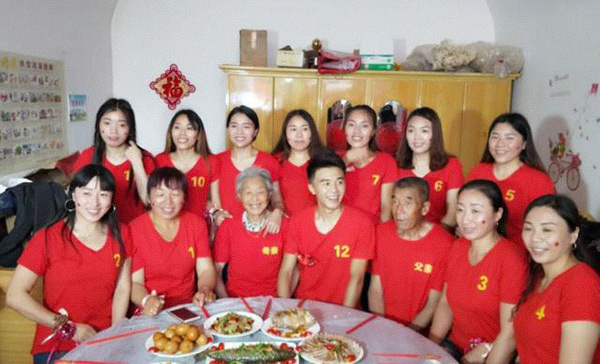 A man poses for a photo with his parents and 11 elder sisters in rural Shanxi province, 2018. Dahe Daily