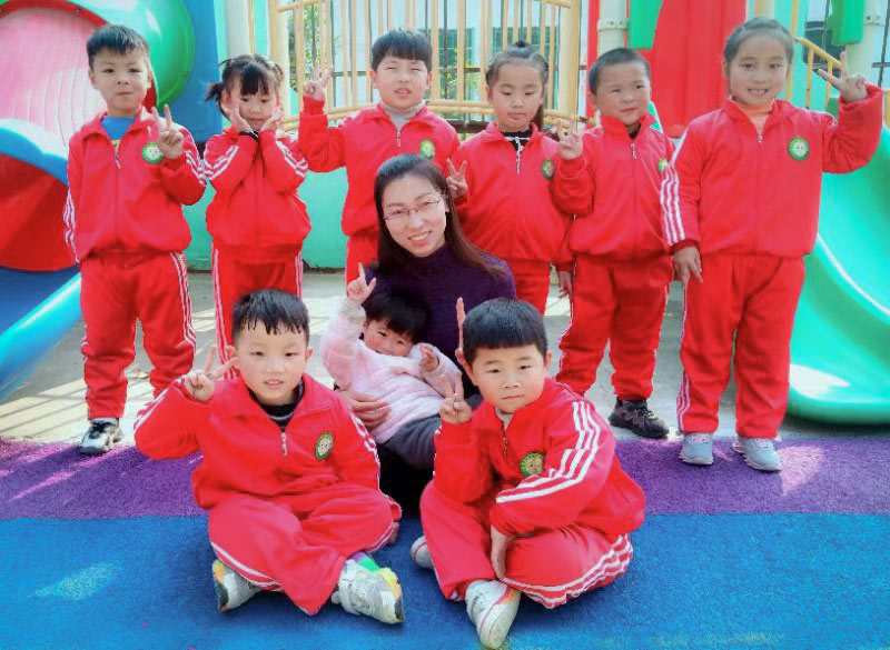 Liu Yue poses for a photo with her daughter and her students at her kindergarten in rural Henan province. Courtesy of Liu Yue