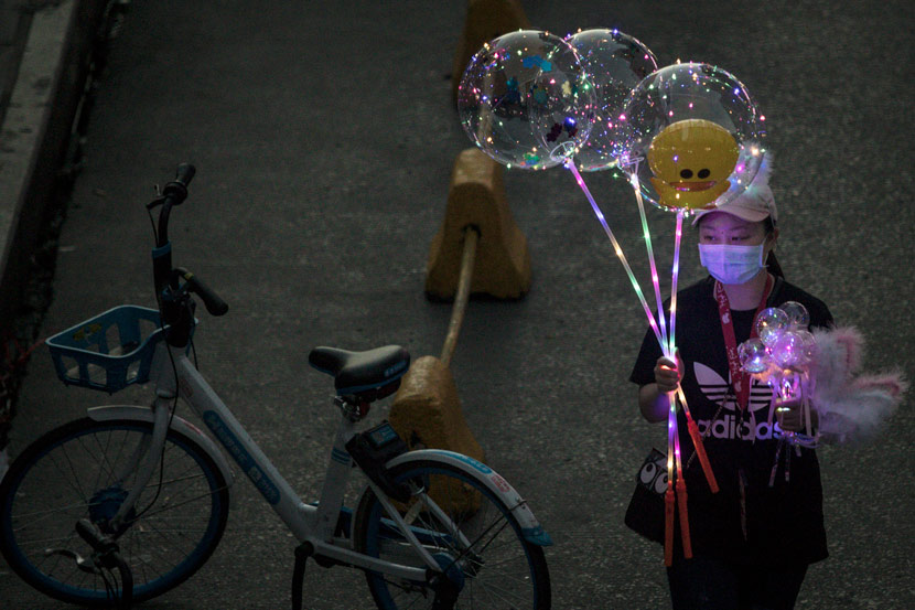 A woman sells balloons at a night market in Wuhan, Hubei province, June 2020. Zhang Muzhi/IC