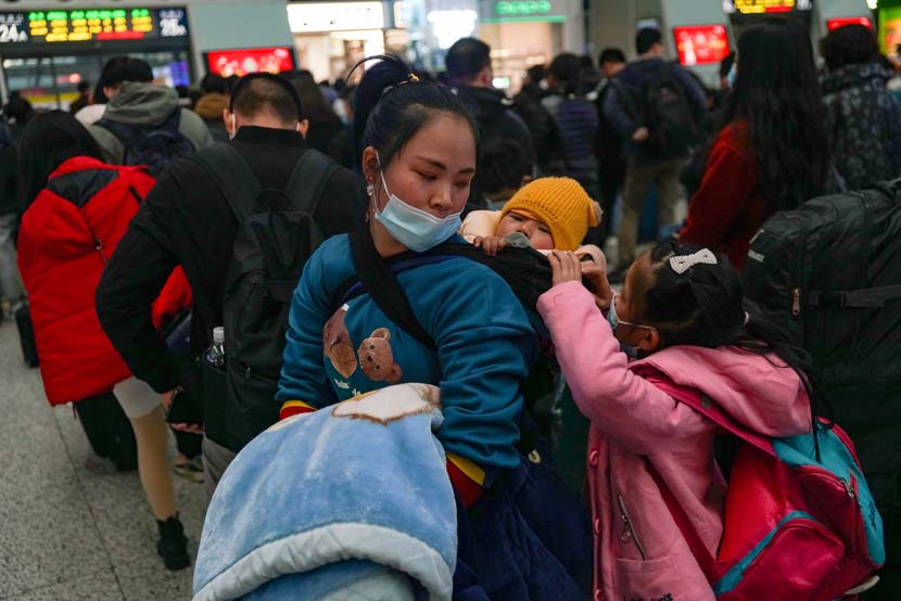 A mother and her children wait in line at a railway station on Thursday, the beginning of this year’s Spring Festival travel period, in Hangzhou, Zhejiang province, Jan. 28, 2021. IC