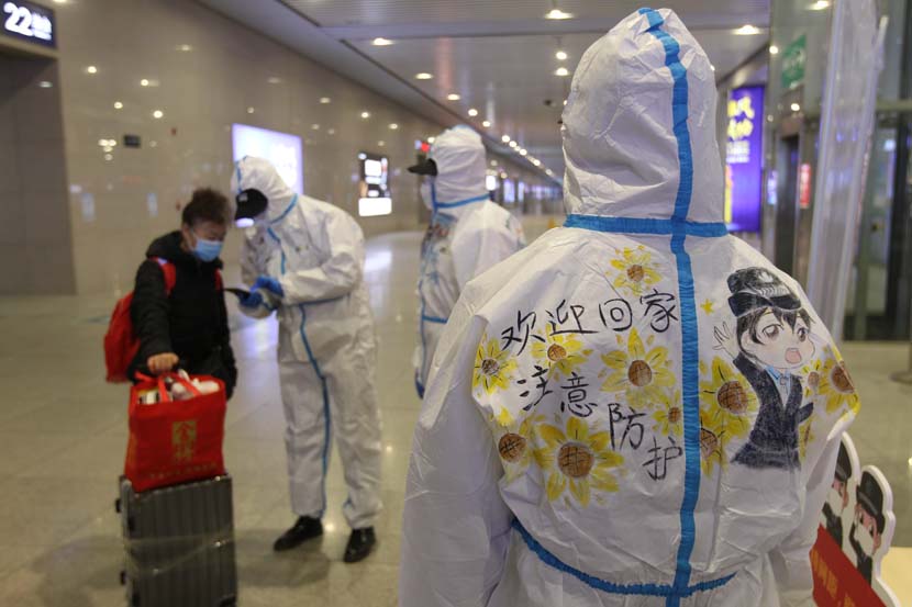 A message scrawled on a disease control worker’s protective suit reads “take care and welcome home,” at Shijiazhuang Railway Station, Hebei province, Jan. 28, 2021. People Visual