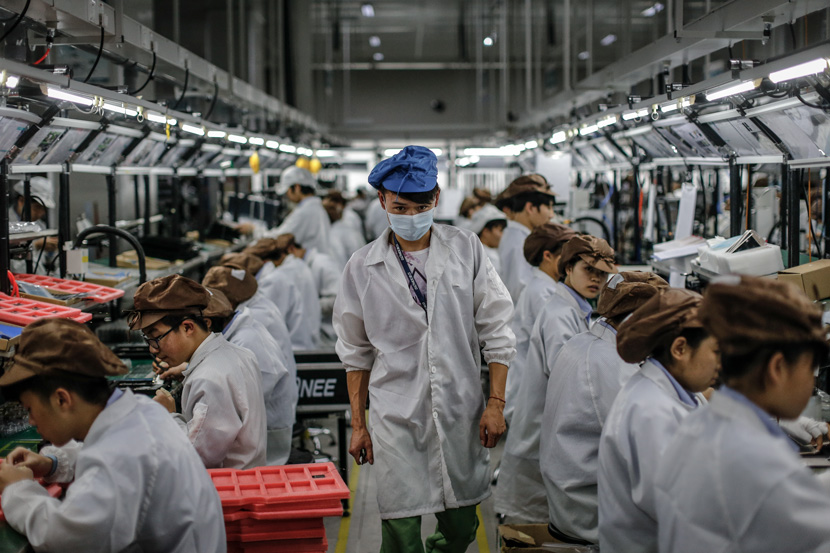 A worker walks through a workshop in Dongguan, Guangdong province, 2015. Liu Xingzhe/People Visual
