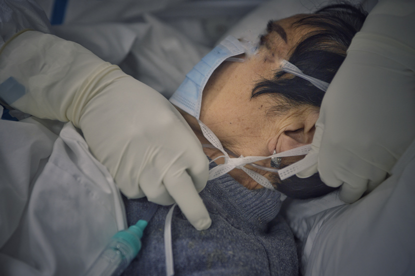 A COVID-19 patient receives medical treatment at Leishenshan Hospital, an emergency pop-up facility in Wuhan, Hubei province, March 2020. People Visual