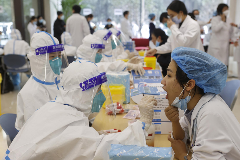 Medical workers take nucleic acid tests at a hospital in Shanghai, Jan. 21, 2021. Yin Liqin/CNS