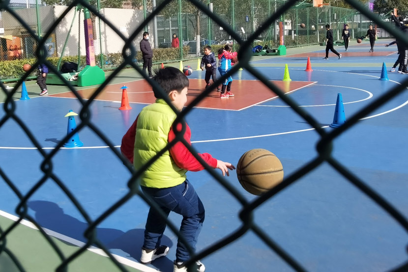 Children take part in a basketball training session run by a private training company in Shanghai, Jan. 9, 2021. Ni Dandan/Sixth Tone