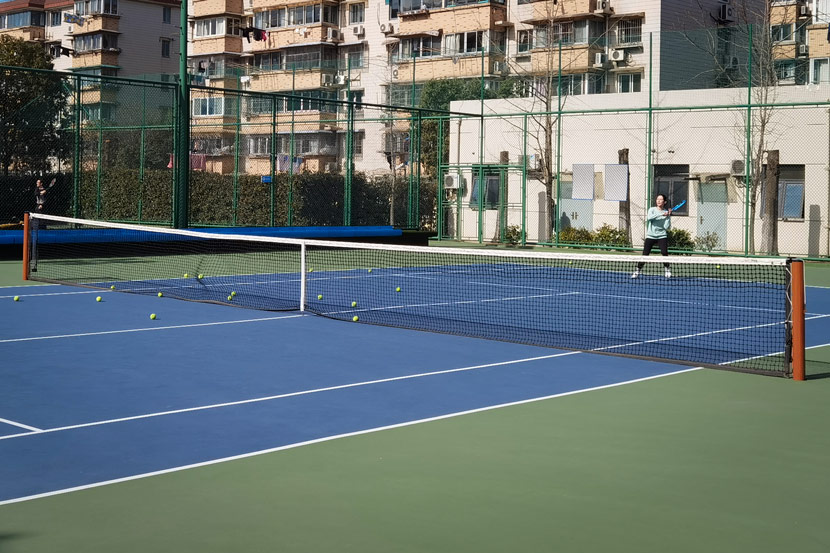 A student practices tennis with a private coach at a court in Pudong New Area, Shanghai, Jan. 9, 2021. Ni Dandan/Sixth Tone