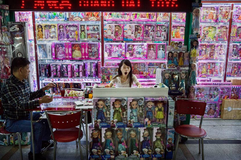 A trader yawns as she waits for customers to visit her stall at the Yiwu International Trade City mall, Zhejiang province, 2015. Kevin Frayer/Getty Images/People Visual