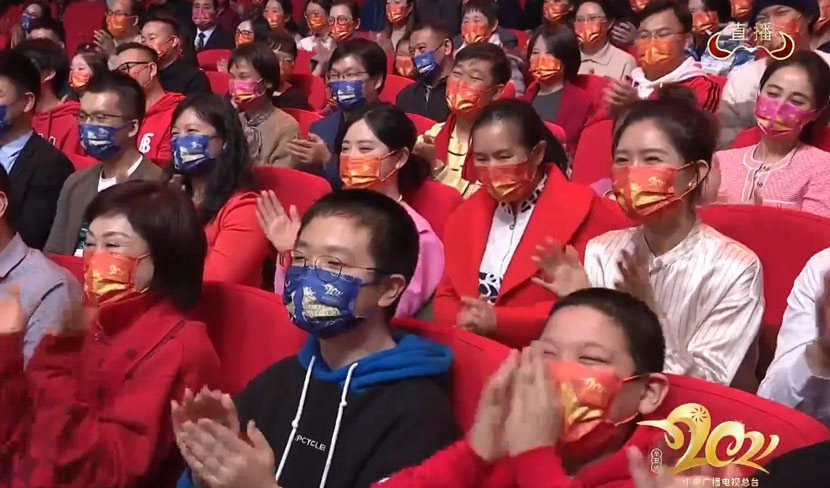 Audience members wearing ox-themed face masks applaud during the 2021 Spring Festival Gala. From @春晚 on Weibo