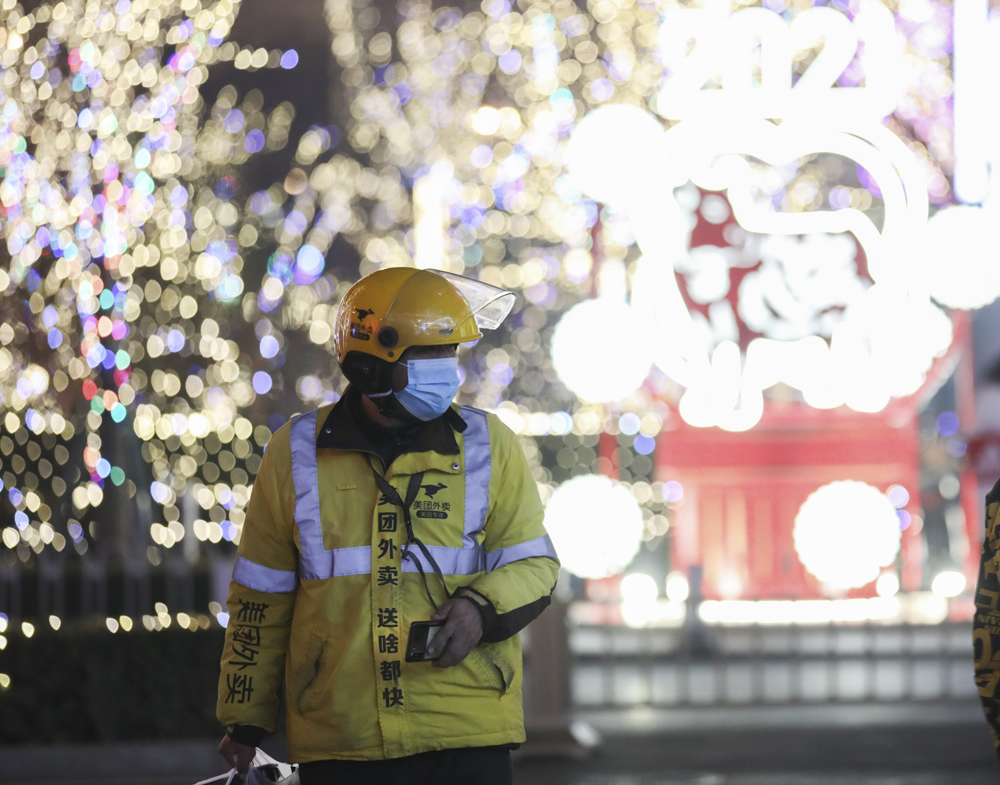 A delivery man works on the first day of the lunar year in Beijing, Feb. 12, 2021. Many migrant workers chose to stay put in the cities this Lunar New Year holiday. Jiang Qiming/CNS/IC