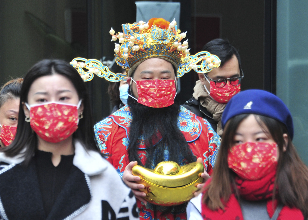 A man in a god of wealth costume wears a holiday-themed face mask in Shanghai, Feb. 15, 2021. Yang Jianzheng/People Visual