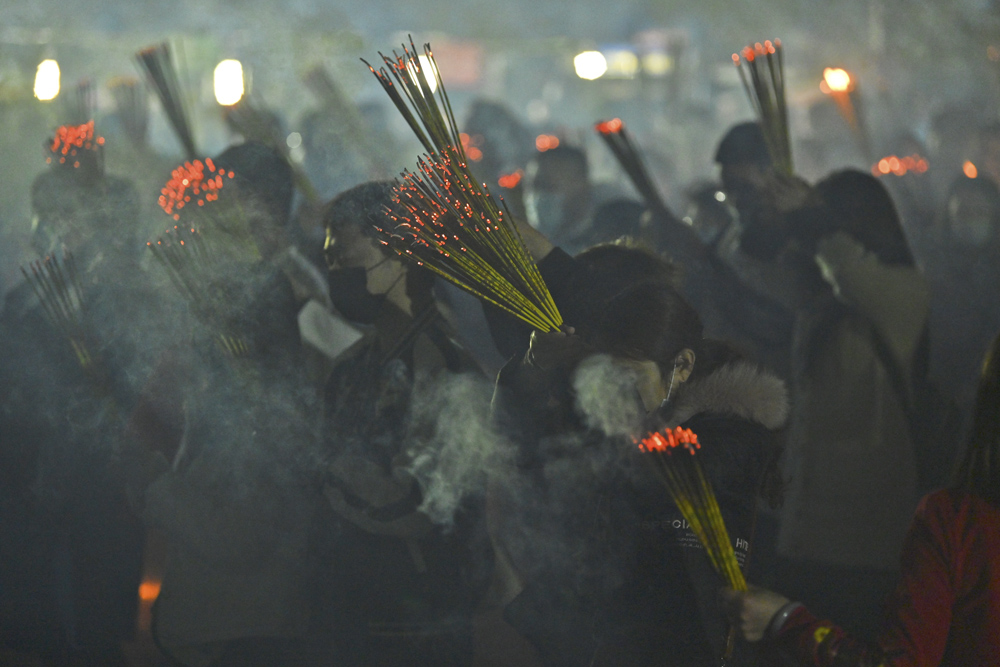 People pray and burn joss sticks piously at a temple on the eve of the Lunar New Year in Nanning, Guangxi Zhuang Autonomous Region, Feb. 11, 2021. People Visual
