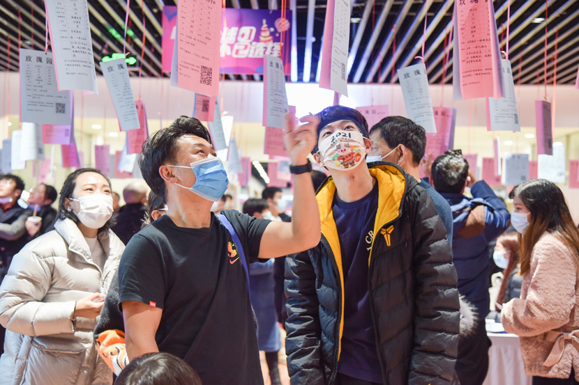 Young people check the information of other attendees at a dating event in Yiwu, Zhejiang province, Feb. 14, 2021. Mao Xuqian/People Visual