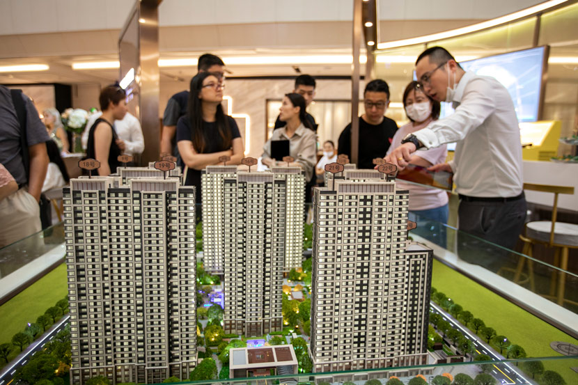 A salesperson introduces a new development to potential buyers at a sales office in Shanghai, Aug. 1, 2020. Lü Liang/IC