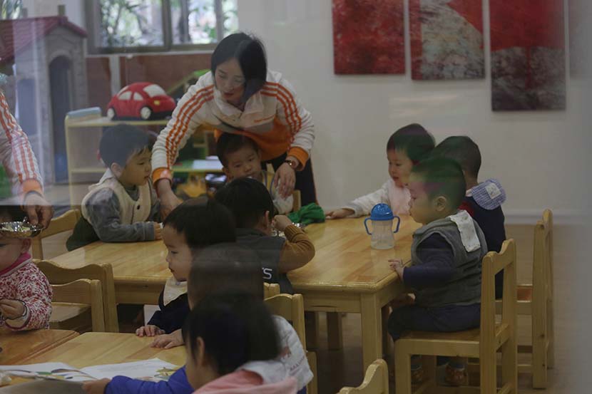 A teacher supervises children during lunchtime at a day care center in Guangzhou, Guangdong province, March 1, 2019. People Visual