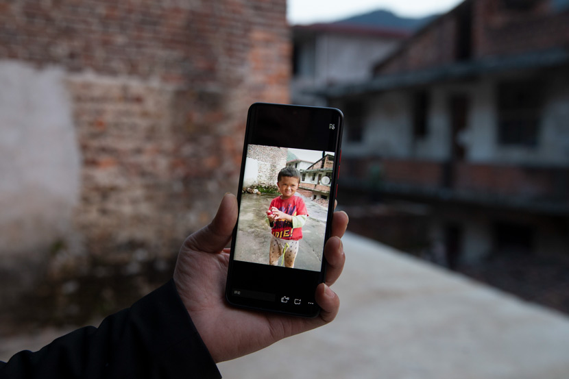 Huang Xinlong, Fan Xiaoqin’s cousin, shows a photo of Xiaoqin on his phone, in Yanhui Village, Ji’an, Jiangxi province, Feb. 22, 2021. Huang created the social post about Xiaoqin’s resemblance to Jack Ma that went viral in 2015. IC