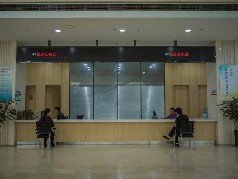 A divorced couple meet at a local housing bureau to transfer the ownership of their house to their daughter, in a photograph from the series “When We Two Parted,” 2019. The couple had recently finalized their divorce. Courtesy of Gao Meilin
