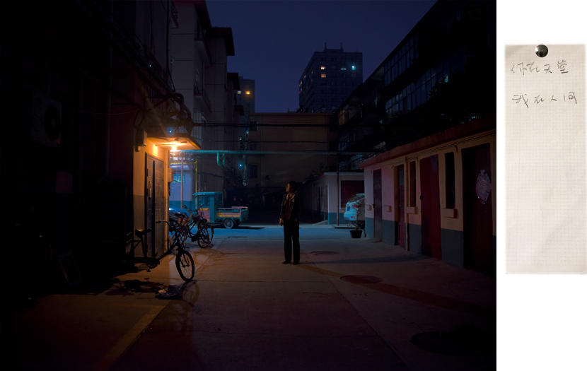 A woman stands outside her old apartment, in a photograph from the series “When We Two Parted,” 2019. The woman’s ex-husband died following their separation. The note she wrote to him, posted on the right, reads: “You are in heaven, while I’m still wandering in this world.” Courtesy of Gao Meilin