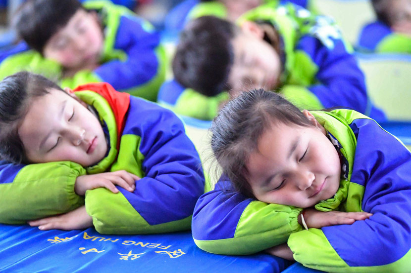 Students take an after-lunch nap a primary school in Bozhou, Anhui province, 2018. Liu Qinli/People Visual