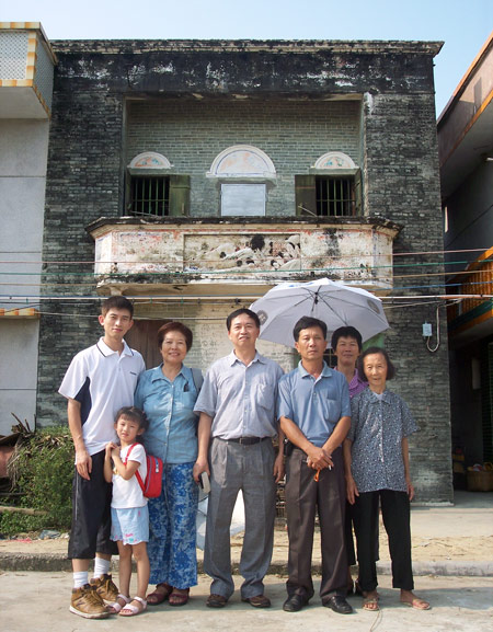 Huang Zhuocai (center) and his family pose for a photo in front of the house Huang Baoshi built in 1937. Courtesy of Huang Zhuocai