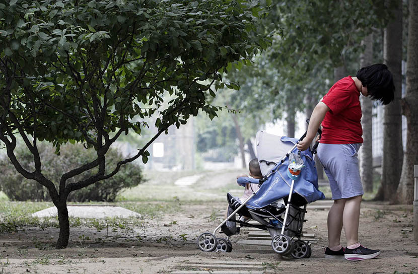 Sisi takes a stroll with her baby girl at a park in Beijing, June 7, 2016. Han Meng/Sixth Tone