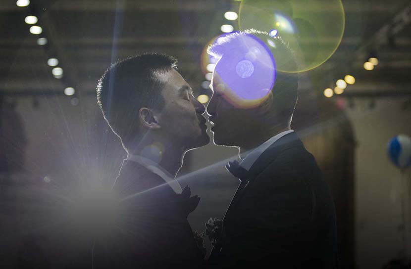 Sun Wenlin (left) and his partner Hu Mingliang lean in to kiss each other during their ceremonial wedding in Changsha, Hunan province, May 17, 2016. Wu Yue/Sixth Tone