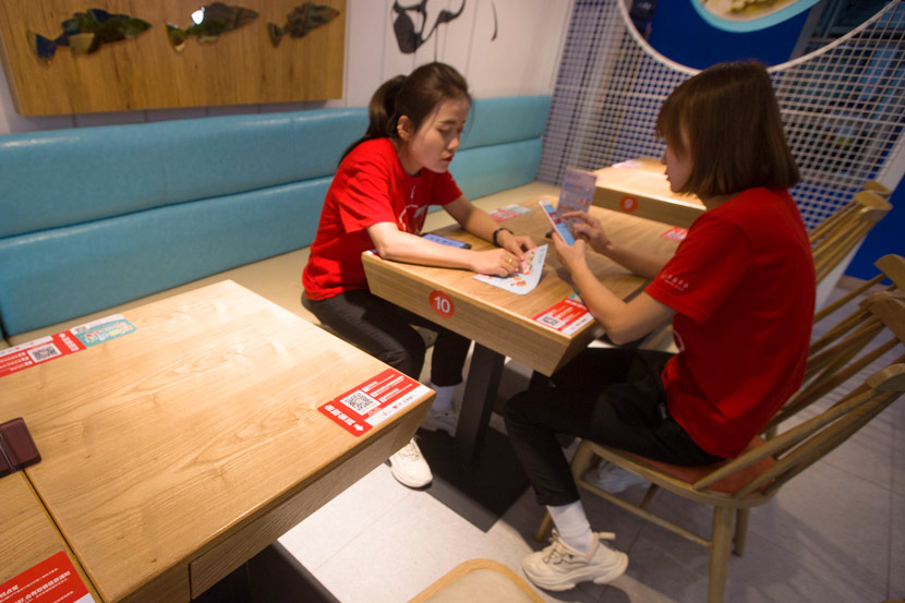 Two women order food with their phones at a restaurant in Taiyuan, Shanxi province, 2018. Zhang Yun/CNS/People Visual