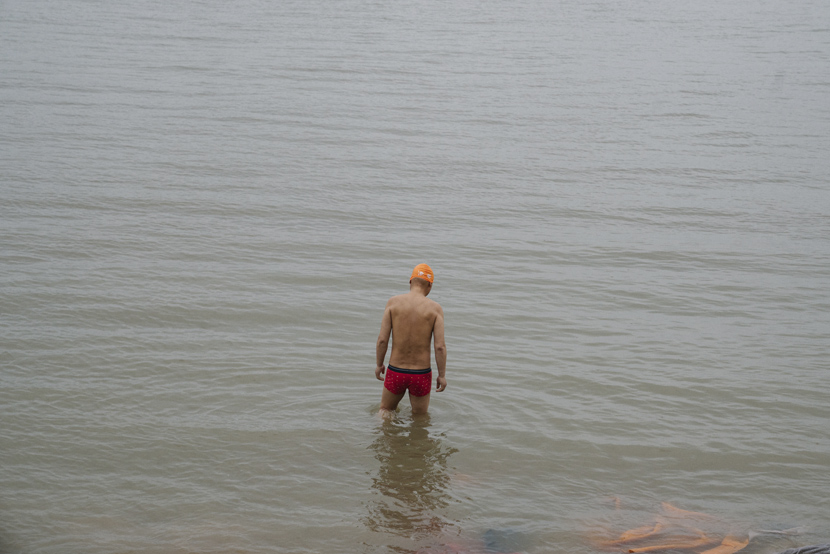 A swimmer wades into the Yangtze River, in Wuhan, Hubei province, April 2, 2021. Shi Yangkun/Sixth Tone