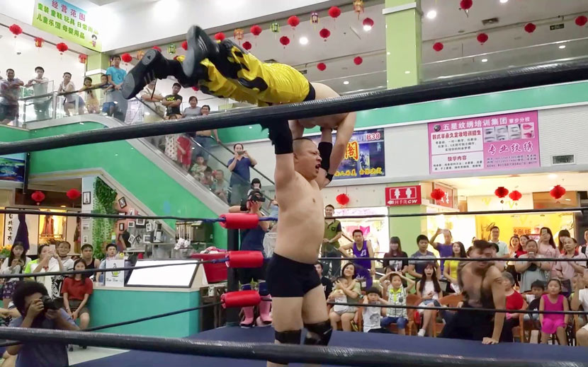 Liu “The Slam” Xuanzheng, founder of China Wrestling Entertainment, China’s first pro wrestling group, lifts up his opponent during a show at a mall in Dongguan, Guangdong province, 2016. Courtesy of Liu Xuanzheng