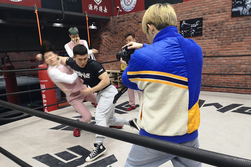 Zhao Junjie is filmed pretending to beat up a group of “little fresh meat” boy band members played by other OWE fighters for a TikTok video, in downtown Shanghai, March 5, 2021. Kenrick Davis/Sixth Tone