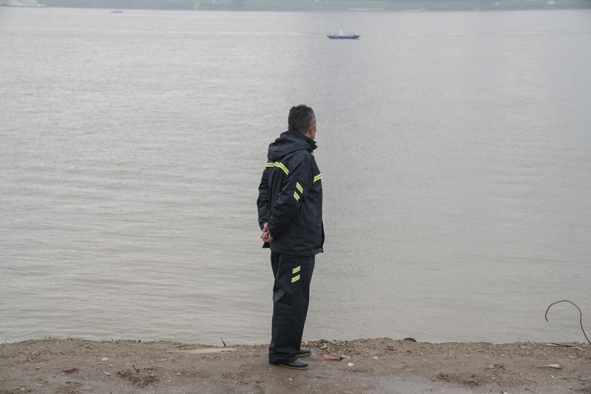 A man stands on the river bank in Wuhan, Hubei province, April 3, 2021. Shi Yangkun/Sixth Tone