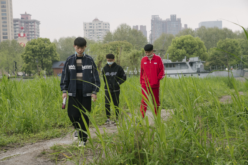 Three teenagers walk along the riverside in Wuhan, Hubei province, April 3, 2021. Shi Yangkun/Sixth Tone
